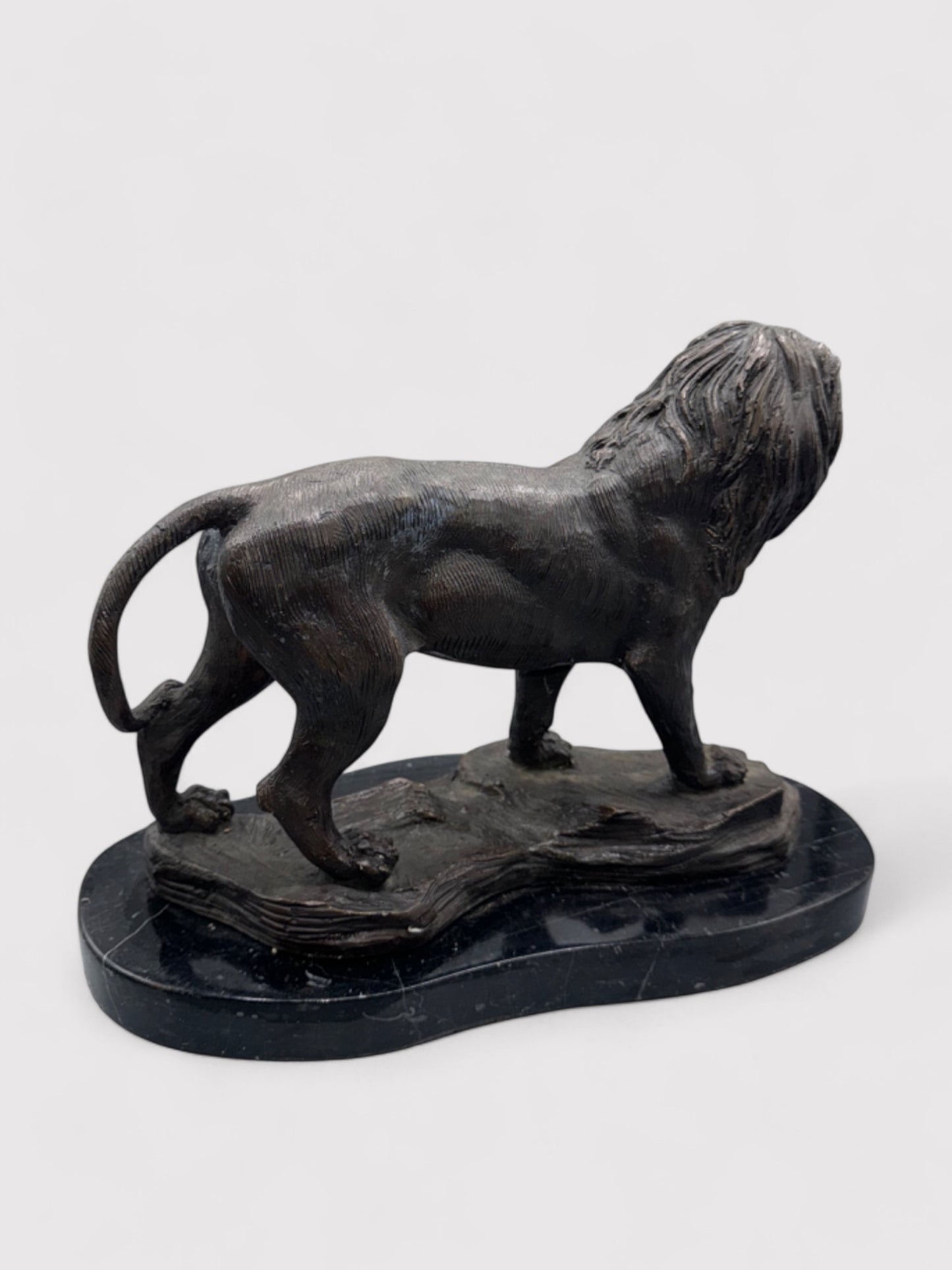 Seitliche Ansicht. Bronzeskulptur eines stehenden Löwen in Dunkelbraun und Schwarz, 24 cm hoch und 30 cm lang; aus massiver Bronze gefertigt, geeignet für Innen- und Außenbereiche. Detaillierte Verarbeitung mit natürlicher Patina, die dem Löwen einen antiken Charakter verleiht. Artikelnummer 0044.