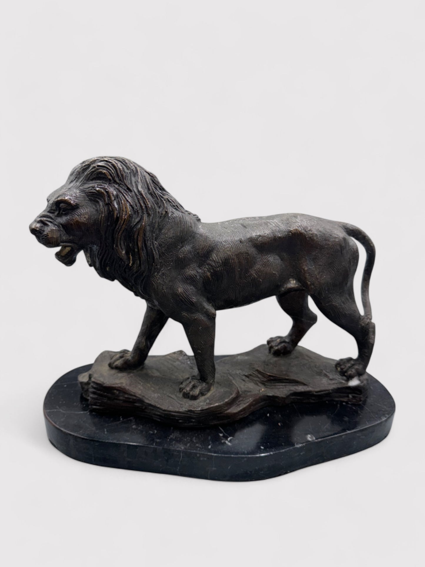 Seitliche Ansicht. Bronzeskulptur eines Löwen in Dunkelbraun und Schwarz, 24 cm hoch und 30 cm lang; aus massiver Bronze gefertigt, geeignet für Innen- und Außenbereiche. Detaillierte Verarbeitung mit natürlicher Patina, die dem Löwen einen antiken Charakter verleiht. Artikelnummer 0044.